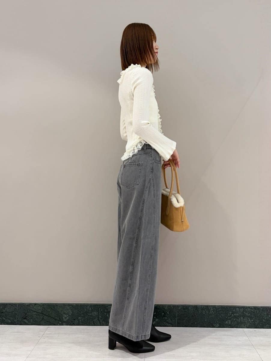 グレー系のデニムパンツ、ホワイト系のニット/セーター、ブラック系のブーツを着用したレディースの夏コーディネートの3枚目の写真