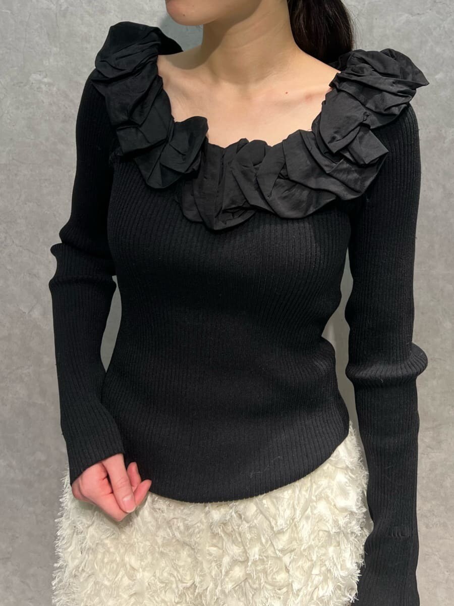 ホワイト系のスカート、ブラック系のニット/セーター、ホワイト系のハンドバッグを着用したレディースの冬コーディネートの3枚目の写真