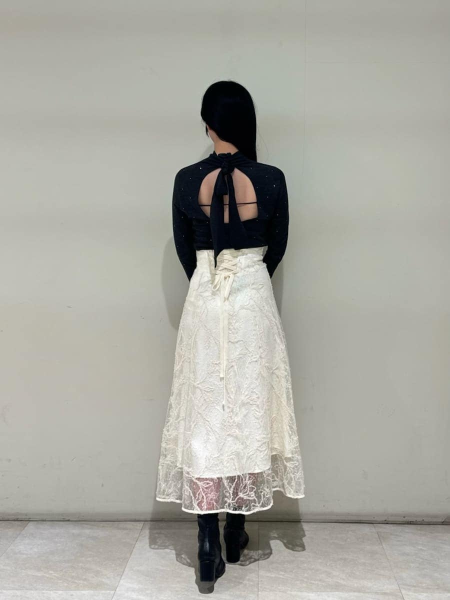 ホワイト系のスカート、グレー系のニット/セーター、ブラック系のハンドバッグを着用したレディースの秋コーディネートの4枚目の写真