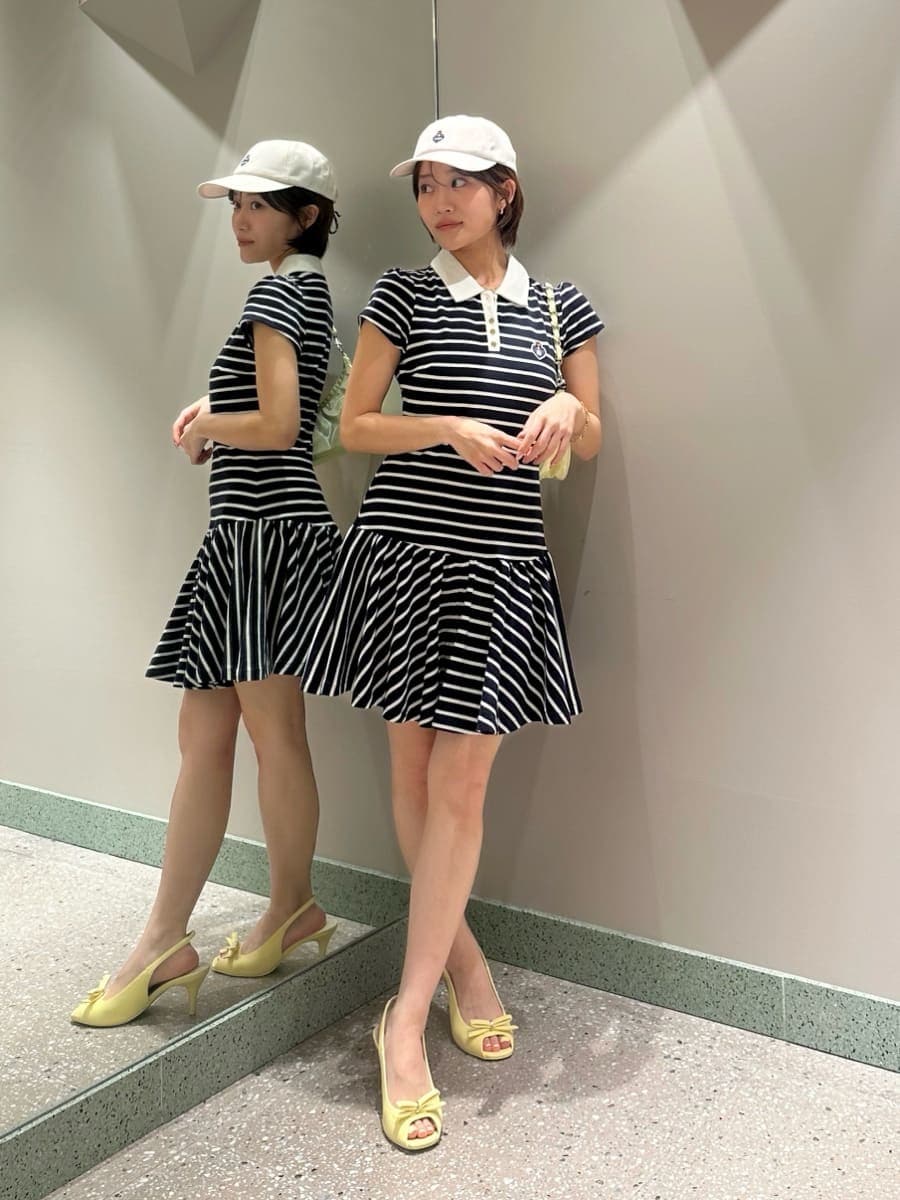 ブルー系のワンピース、イエロー系のショルダーバッグ、ホワイト系のキャップを着用したレディースの夏コーディネートの5枚目の写真