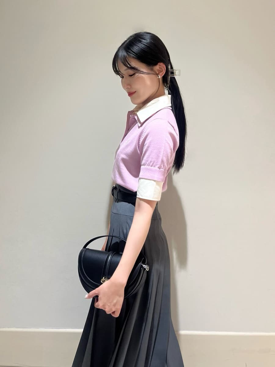 ピンク系のニット/セーター、グレー系のスカート、ブラック系のハンドバッグを着用したレディースの夏コーディネートの4枚目の写真