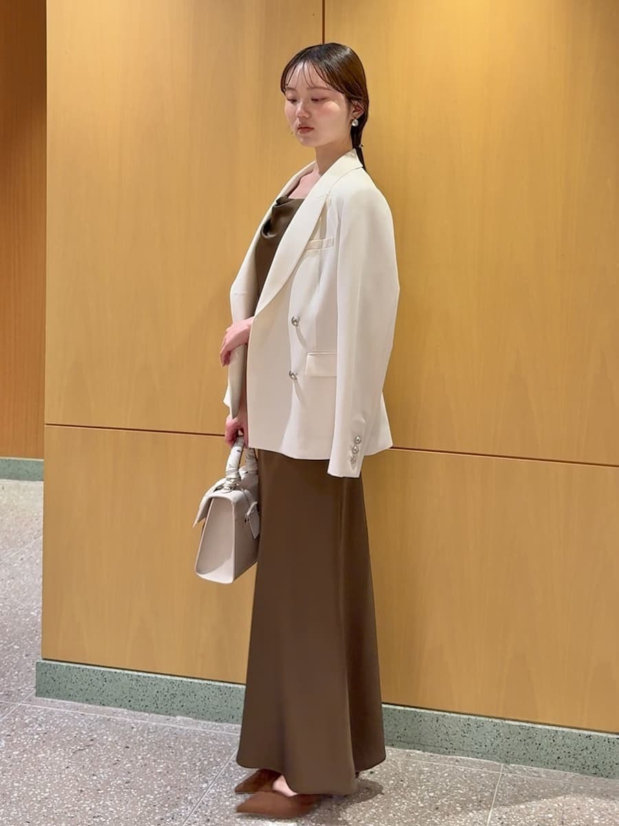 ホワイト系のテーラードジャケット、ブラウン系のパンプス、ベージュ系のハンドバッグを着用したレディースの春コーディネートの2枚目の写真