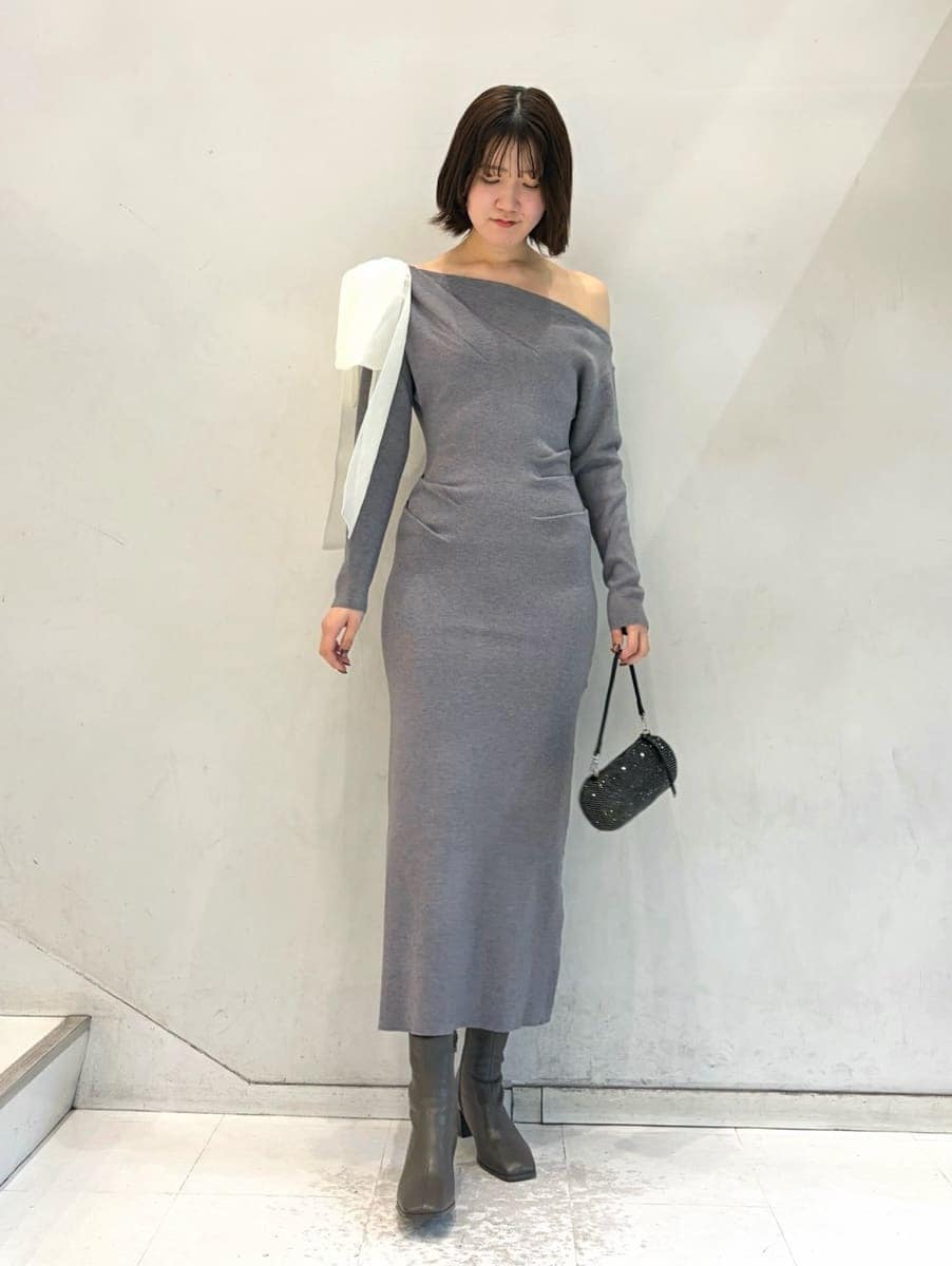 グレー系のワンピース、その他のイヤリングを着用したレディースの冬コーディネートの2枚目の写真