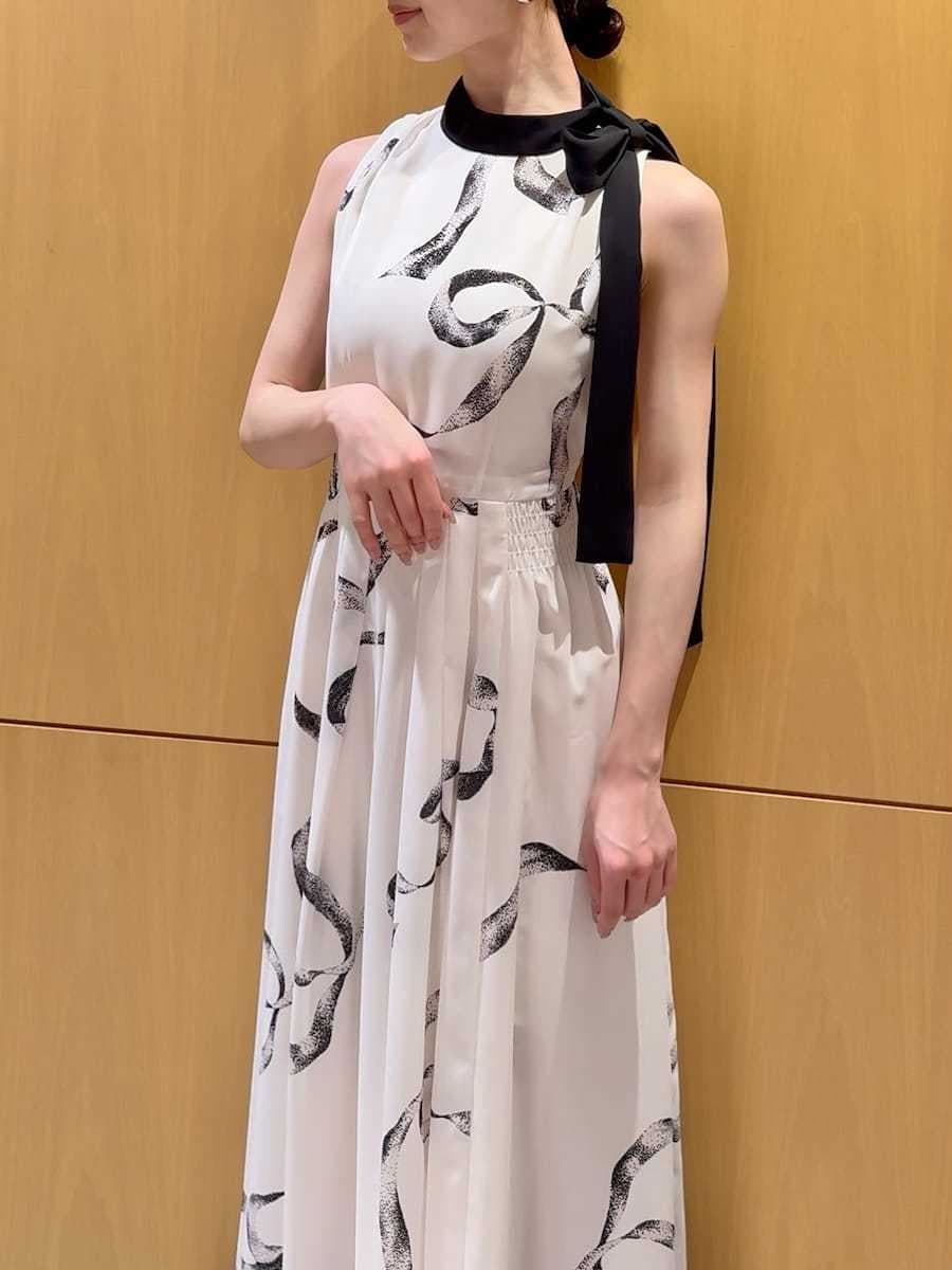 ホワイト系のワンピース、ブラック系のブルゾン、ブラック系のハンドバッグを着用したレディースの春コーディネートの7枚目の写真