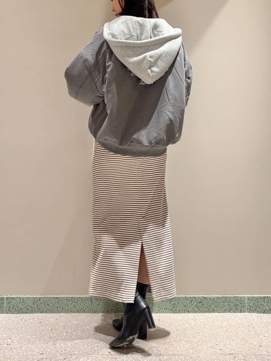 グレー系のブルゾン、ホワイト系のワンピース、ブラック系のハンドバッグを着用したレディースの秋コーディネートの3枚目の写真