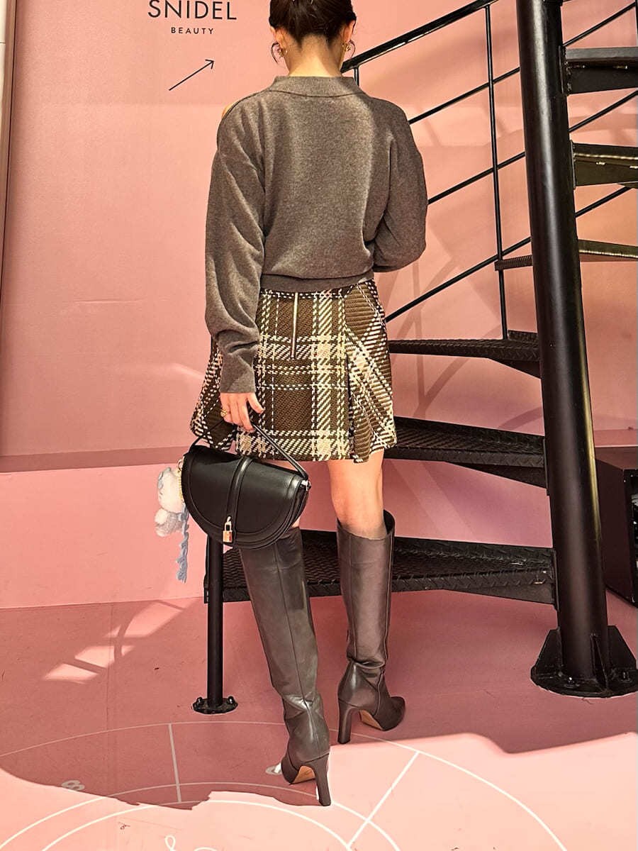 ブラウン系のニット/セーター、ブラウン系のスカート、グレー系のブーツを着用したレディースの秋コーディネートの7枚目の写真