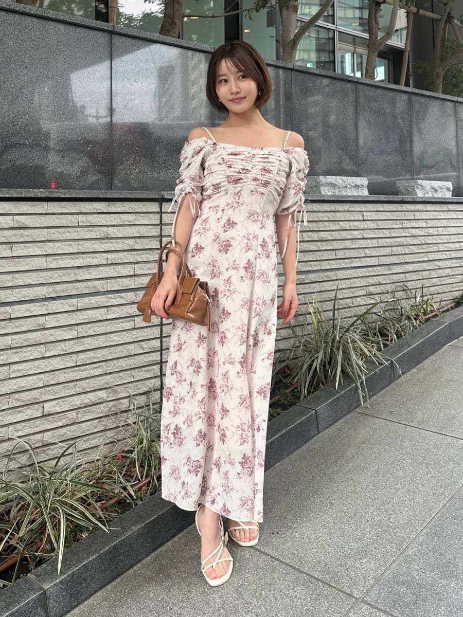 イエロー系のボストンバッグ、ピンク系のワンピースを着用したレディースの冬コーディネートの2枚目の写真