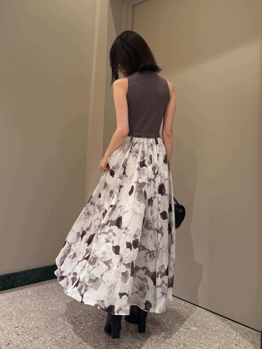 グレー系のワンピース、ブラック系のハンドバッグ、ブラック系のブーツを着用したレディースの秋コーディネートの3枚目の写真