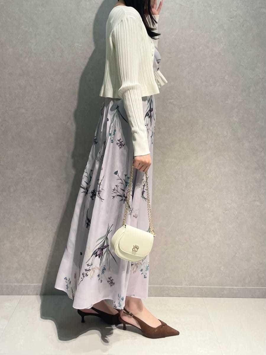 ホワイト系のカーディガン/ボレロ、パープル系のワンピース、ブラウン系のパンプスを着用したレディースの冬コーディネートの5枚目の写真