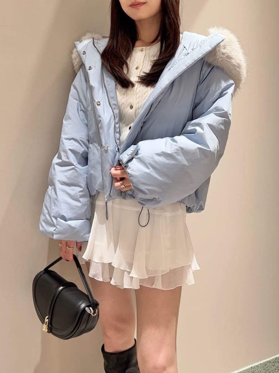 ブラック系のハンドバッグ、ブルー系のダウンジャケット/コート、ホワイト系のその他パンツを着用したレディースの秋コーディネートの6枚目の写真