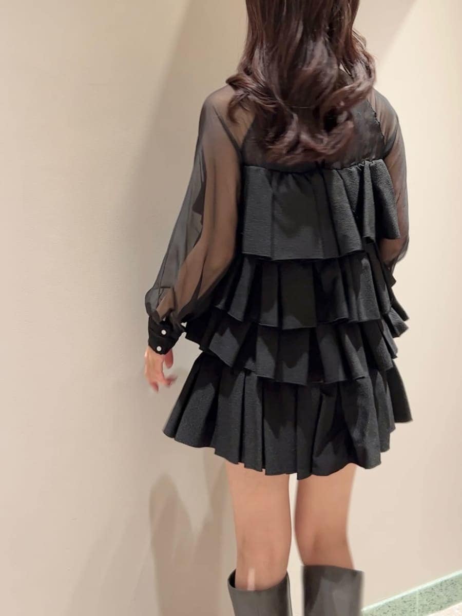 グレー系のブーツ、グレー系のチェスターコート、ブラック系のドレスを着用したレディースの冬コーディネートの7枚目の写真