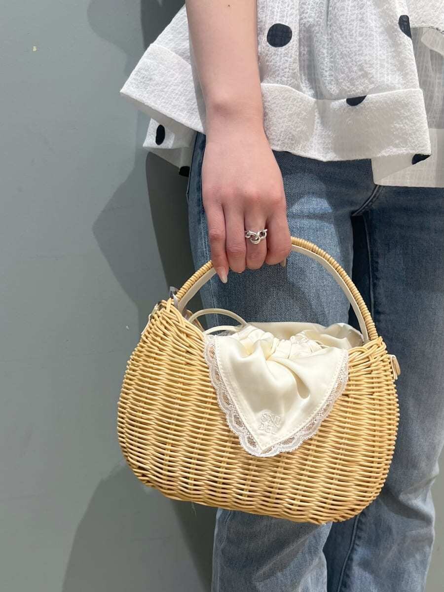 ブルー系のデニムパンツ、ホワイト系のかごバッグ、ホワイト系のシャツ/ブラウスを着用したレディースの春コーディネートの6枚目の写真
