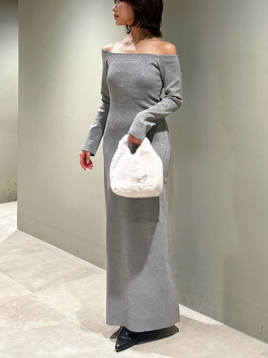 ブラック系のブーツ、シルバー系のワンピース、ホワイト系のハンドバッグを着用したレディースの冬コーディネートの5枚目の写真