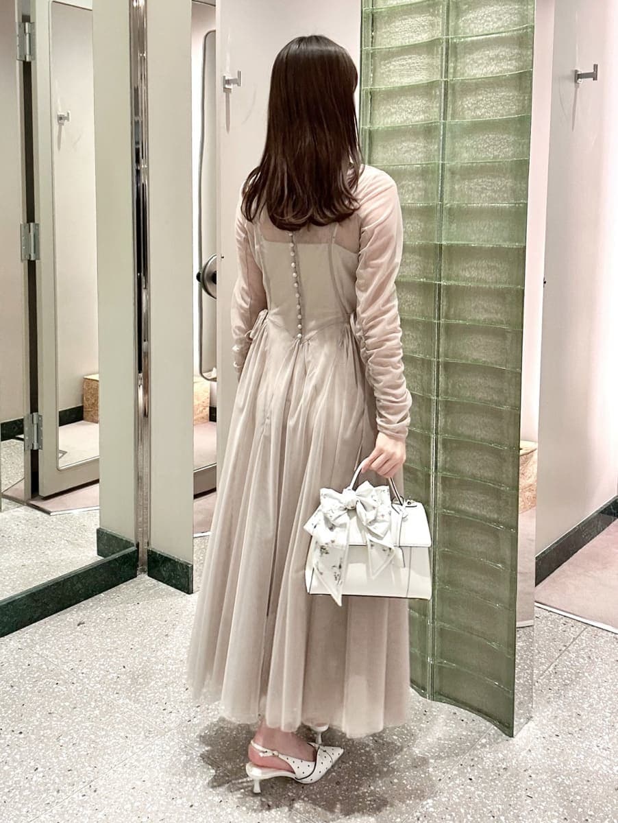 グレー系のドレス、その他のパンプス、ホワイト系のハンドバッグを着用したレディースの冬コーディネートの4枚目の写真