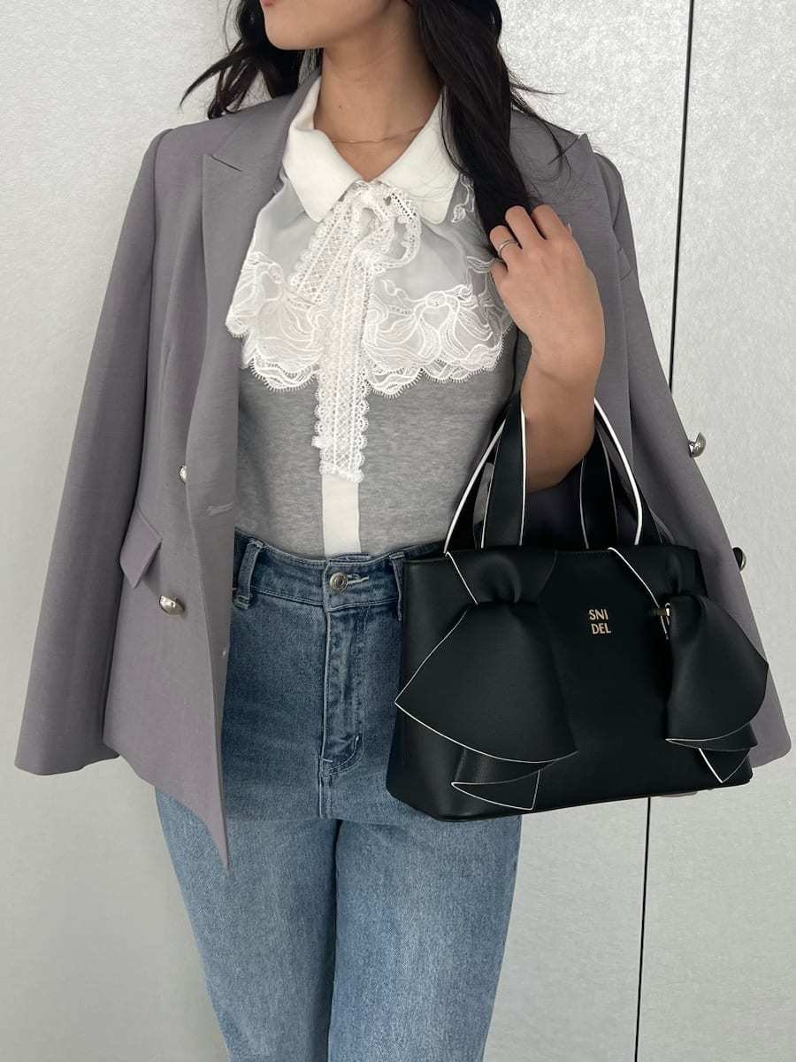 ブルー系のその他パンツ、グレー系のテーラードジャケット、グレー系のニット/セーターを着用したレディースの春コーディネートの3枚目の写真