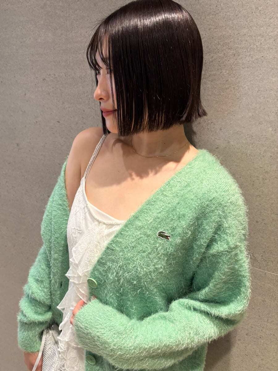 ホワイト系のワンピース、グリーン系のカーディガン/ボレロ、ブラック系のブーツを着用したレディースの冬コーディネートの5枚目の写真