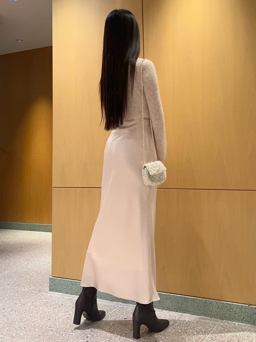 レッド系のブーツ、ホワイト系のショルダーバッグ、ピンク系のワンピースを着用したレディースの秋コーディネートの5枚目の写真