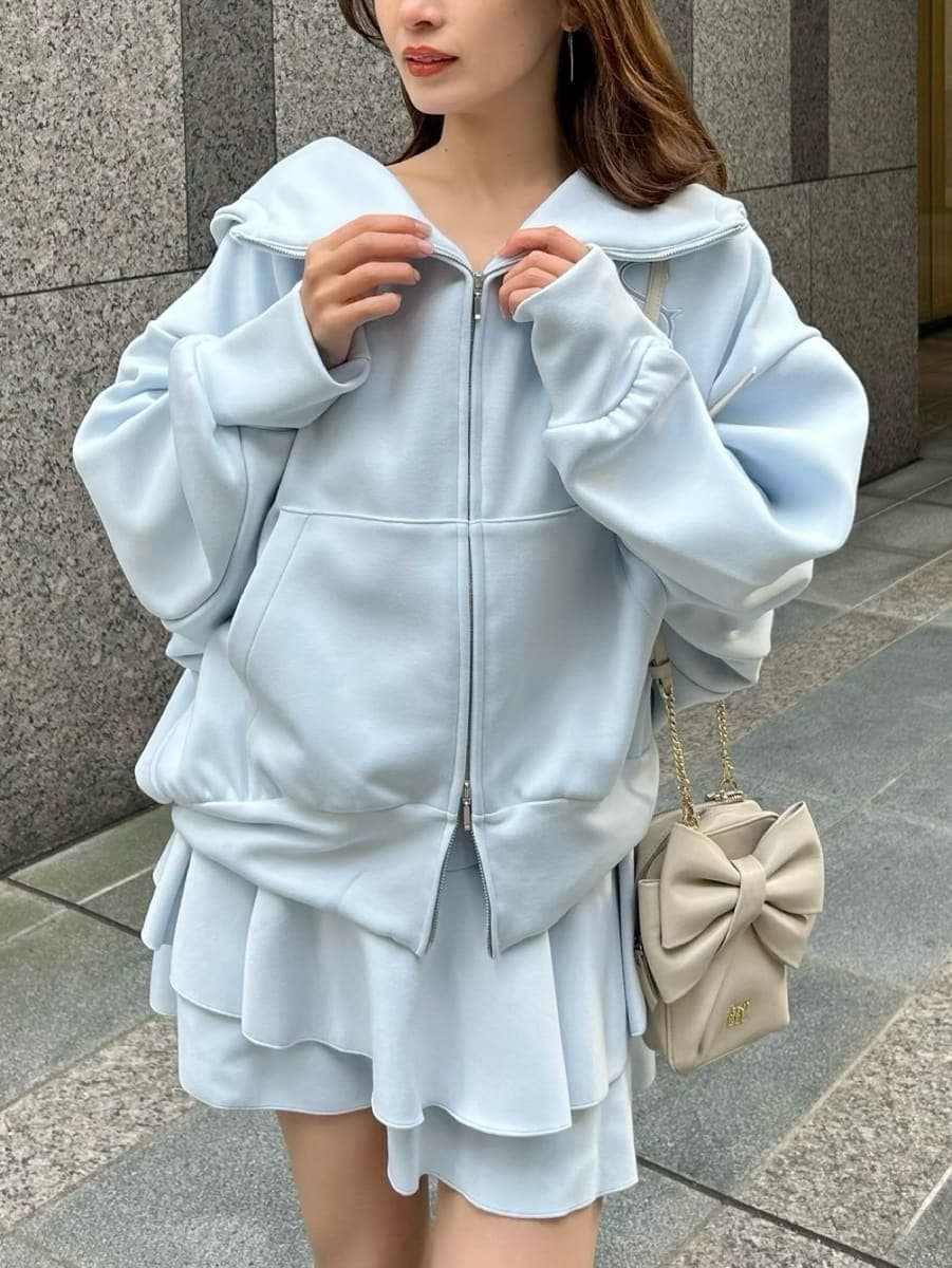 ブルー系のパーカー、ホワイト系のショルダーバッグ、ブルー系のその他パンツを着用したレディースの冬コーディネートの2枚目の写真