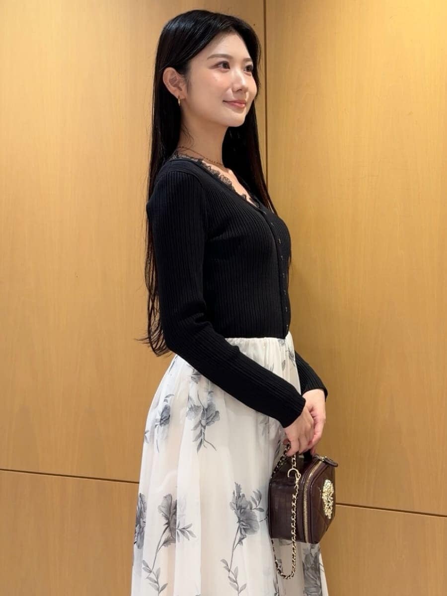 ブラック系のワンピース、ブラック系のパンプス、レッド系のショルダーバッグを着用したレディースの秋コーディネートの5枚目の写真