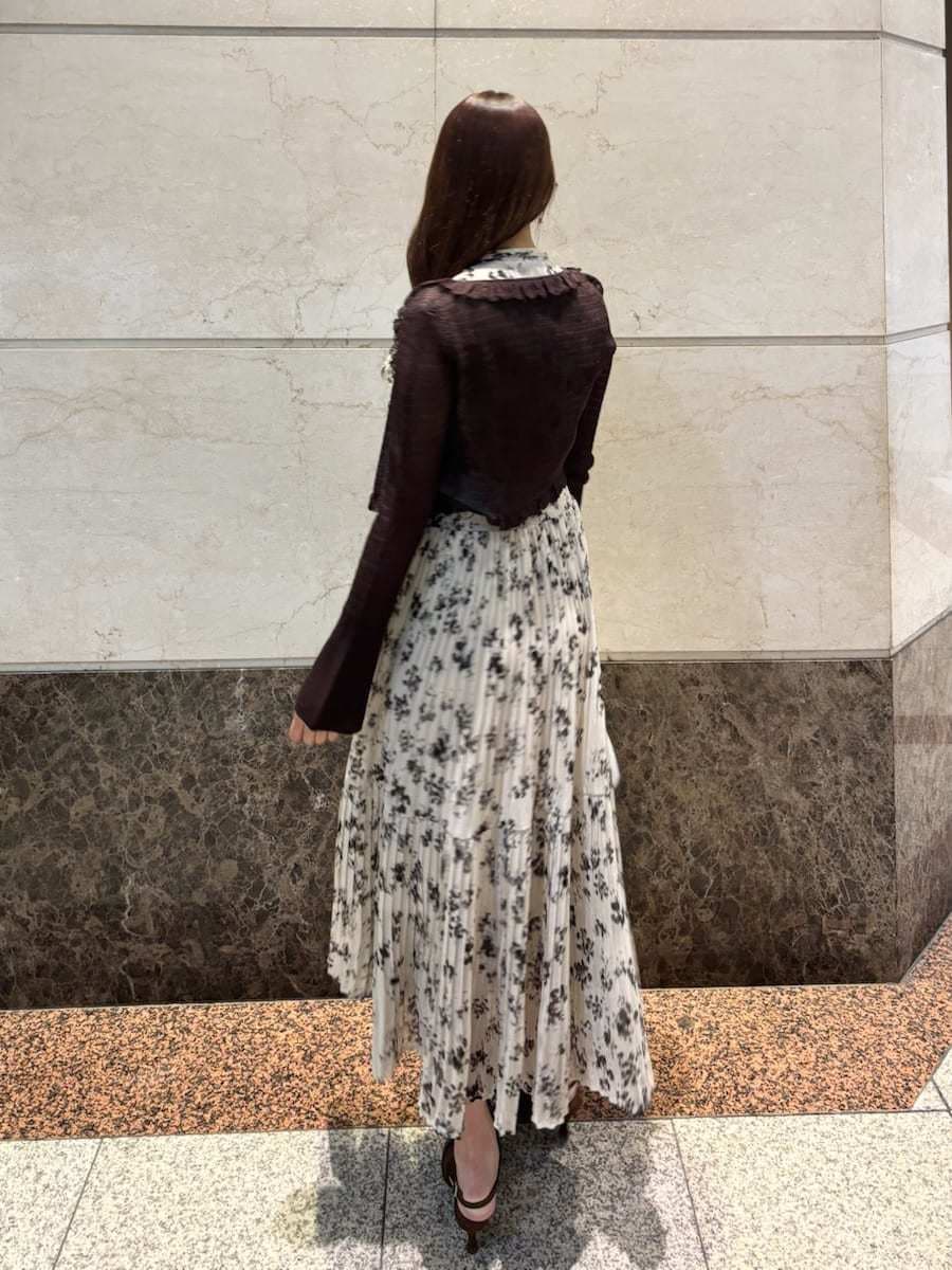 ベージュ系のワンピース、ホワイト系のカーディガン/ボレロ、ブラウン系のパンプスを着用したレディースの冬コーディネートの5枚目の写真