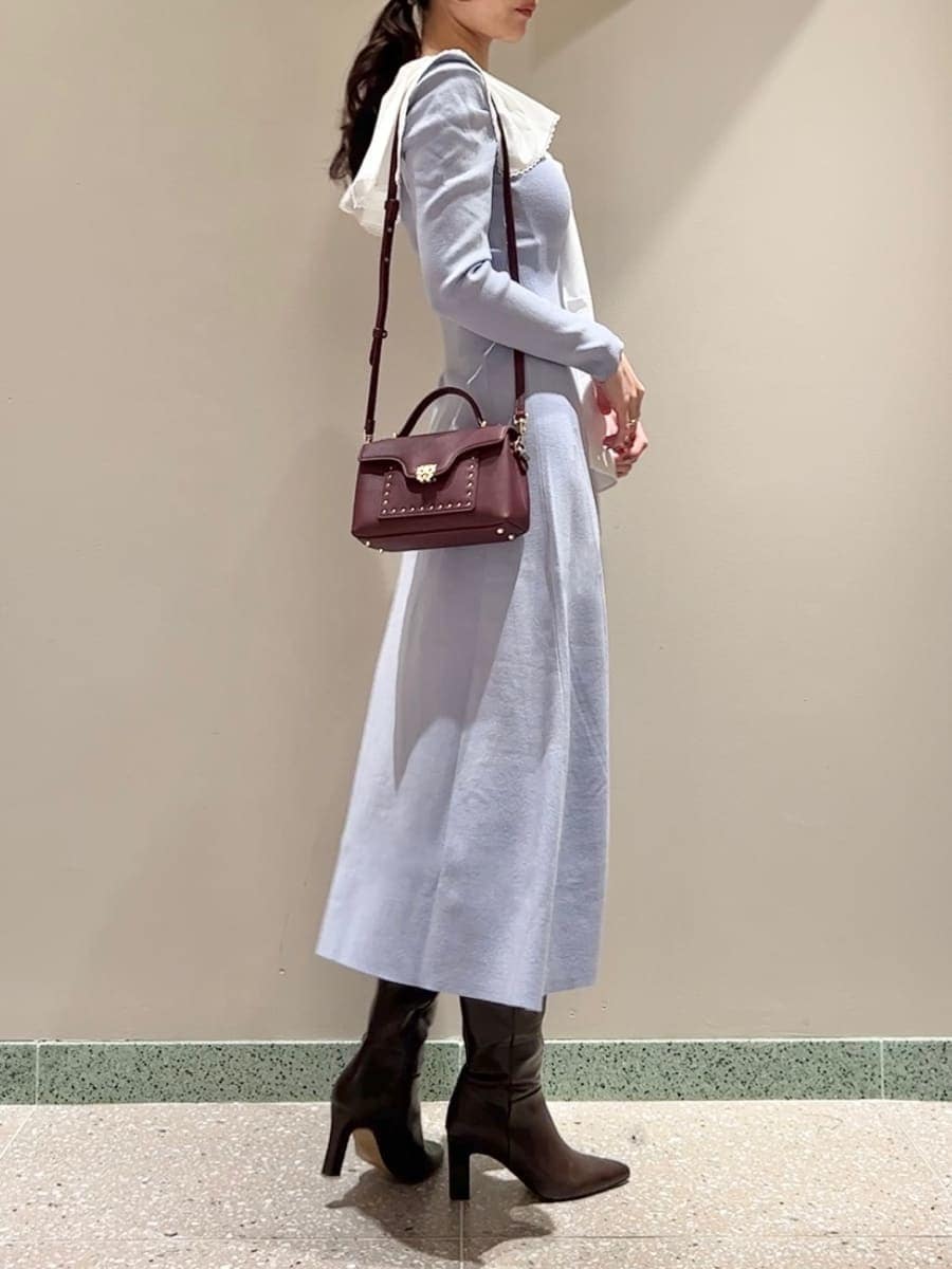 ブラウン系のブーツ、ブラウン系のショルダーバッグ、ブルー系のワンピースを着用したレディースの冬コーディネートの3枚目の写真