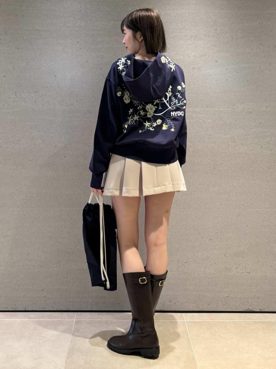 ベージュ系のスカート、ホワイト系のパーカー、ブルー系のバックパック/リュックを着用したレディースの冬コーディネートの3枚目の写真