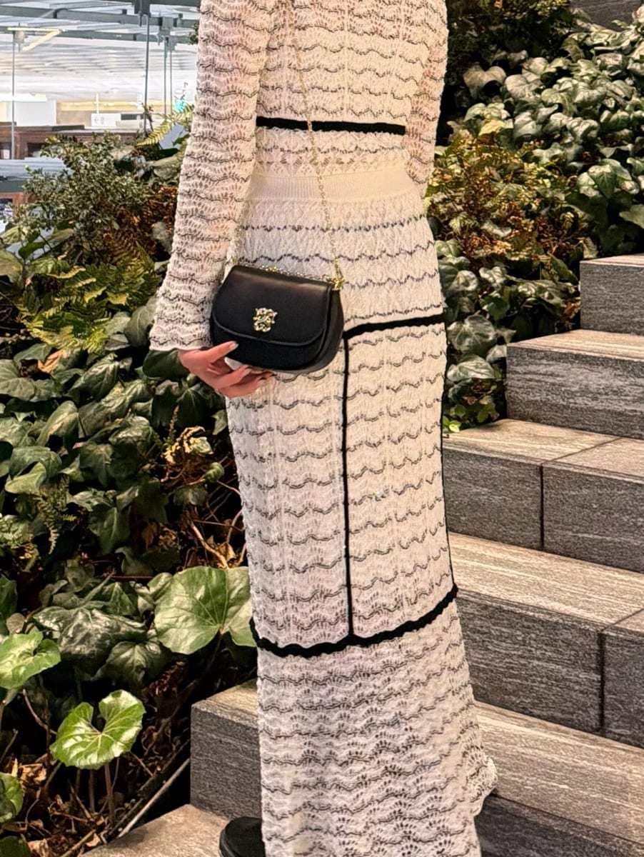 その他のスカート、その他のニット/セーター、ブラック系のショルダーバッグを着用したレディースの春コーディネートの9枚目の写真