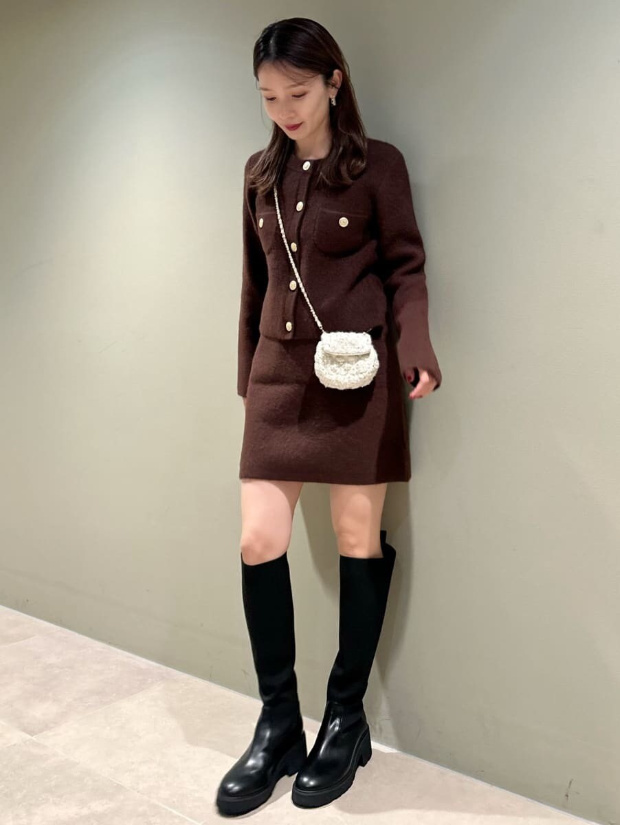 ブラウン系のノーカラージャケット、ブラウン系のスカート、ホワイト系のショルダーバッグを着用したレディースの秋コーディネートの2枚目の写真