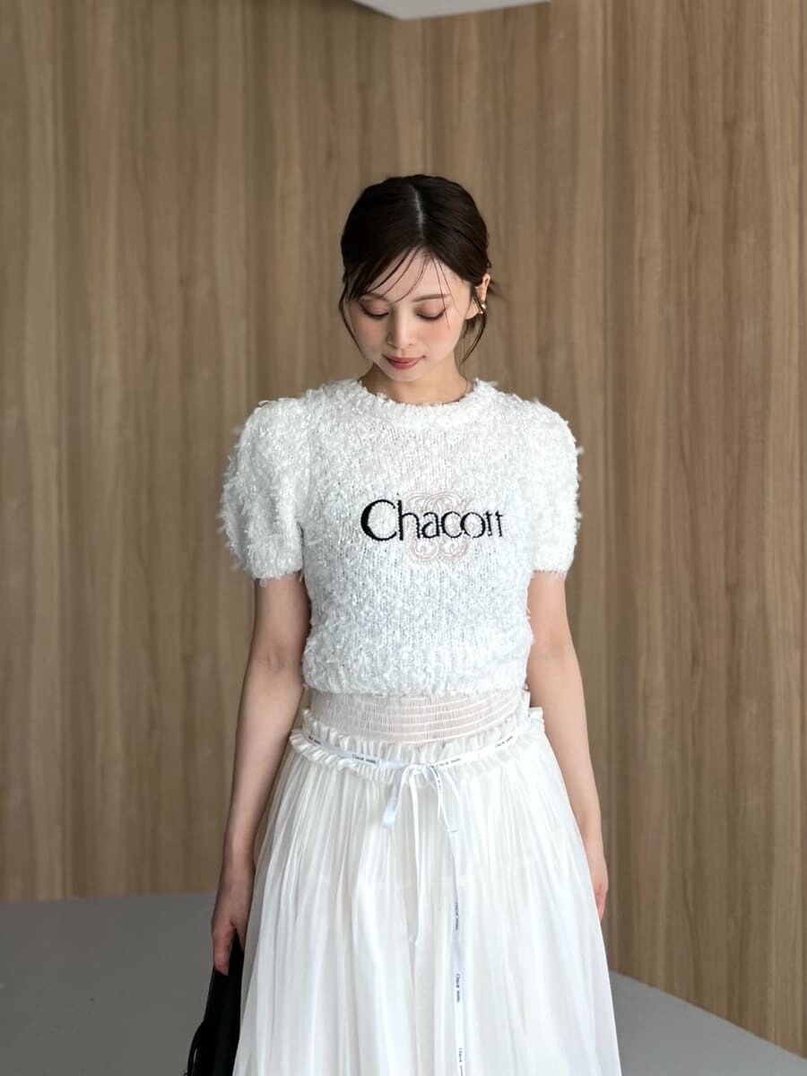 ホワイト系のニット/セーター、ホワイト系のスカート、ブラック系のハンドバッグを着用したレディースの夏コーディネートの5枚目の写真