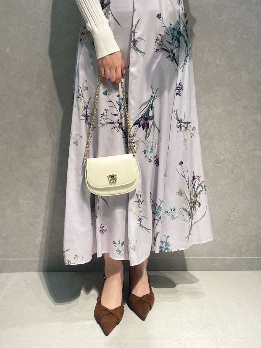 ホワイト系のカーディガン/ボレロ、パープル系のワンピース、ブラウン系のパンプスを着用したレディースの冬コーディネートの7枚目の写真