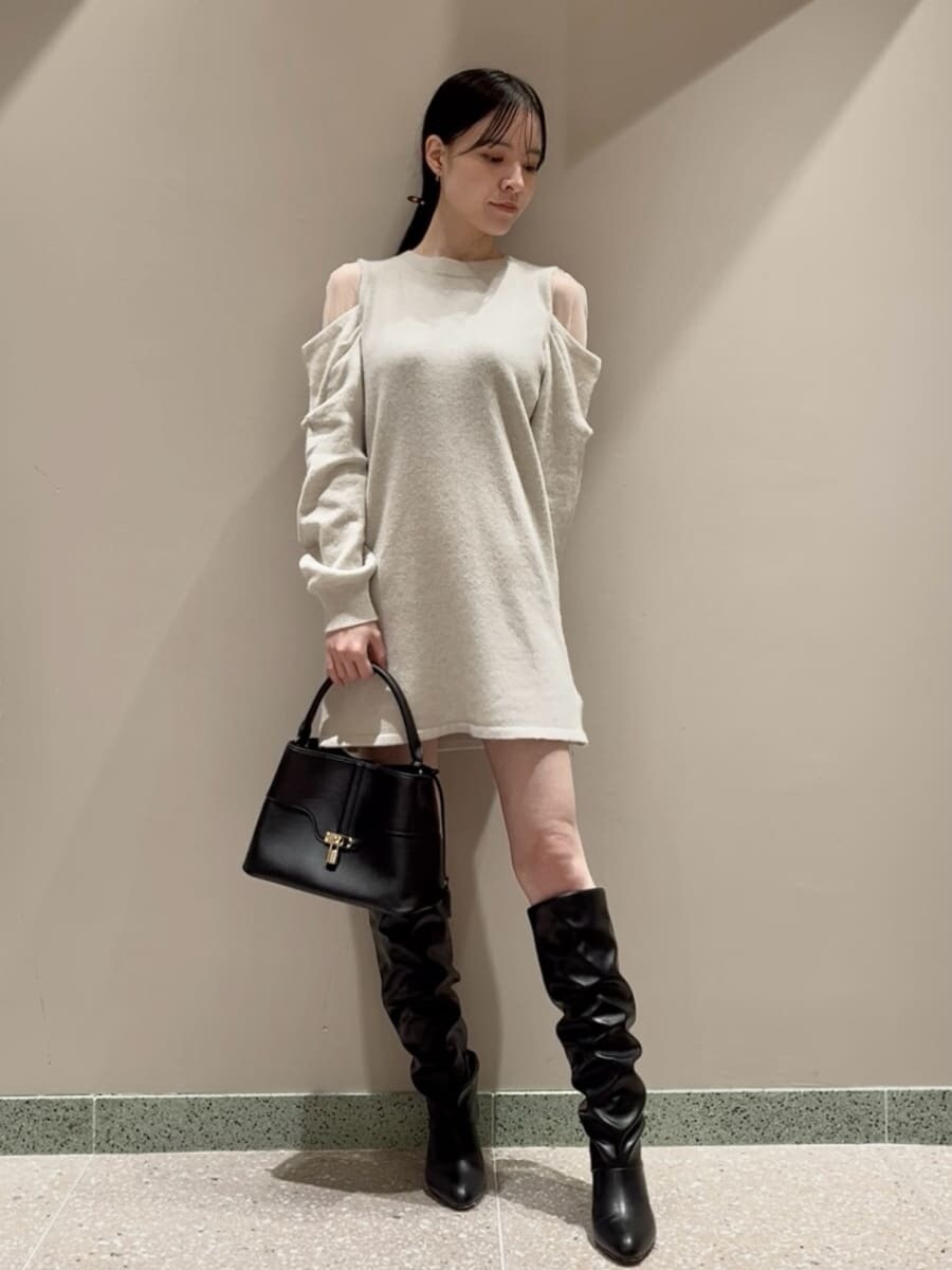 ホワイト系のワンピース、ベージュ系のピーコート、ブラック系のハンドバッグを着用したレディースの冬コーディネートの3枚目の写真