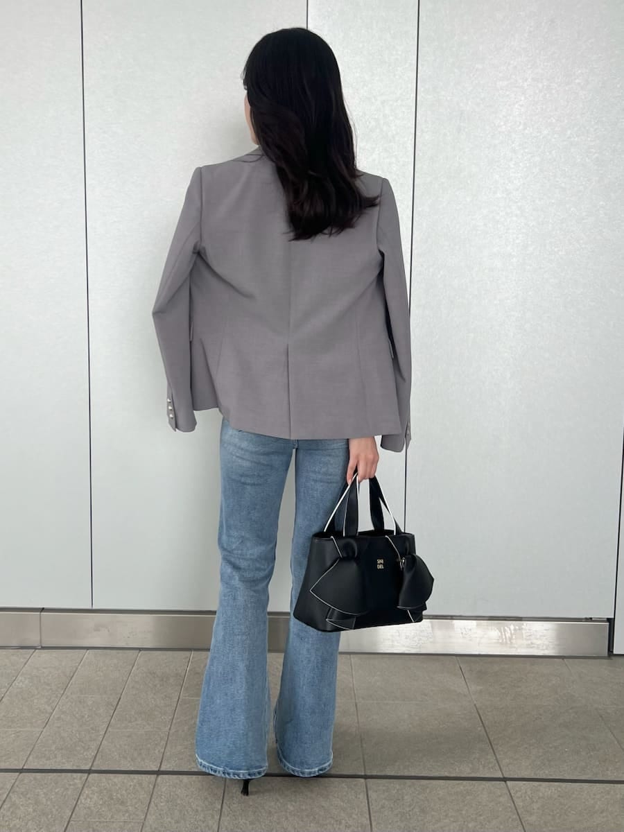 ブルー系のその他パンツ、グレー系のテーラードジャケット、グレー系のニット/セーターを着用したレディースの春コーディネートの2枚目の写真