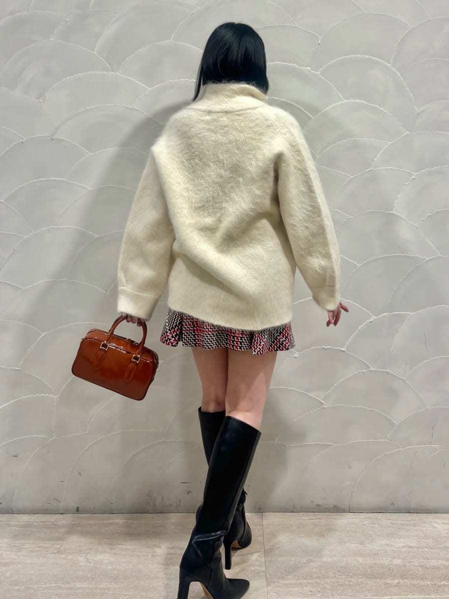 ホワイト系のブルゾン、レッド系のスカート、ブラック系のブーツを着用したレディースの冬コーディネートの2枚目の写真