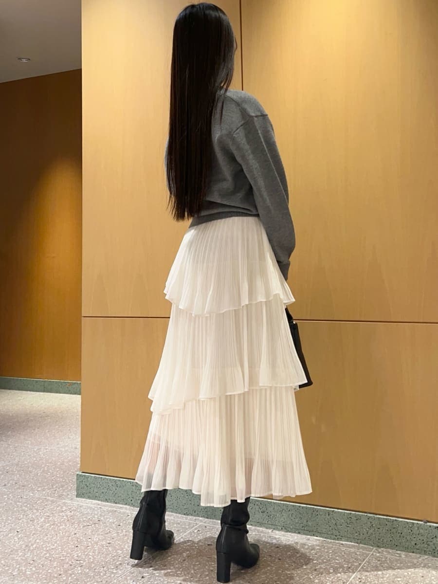 ブラック系のブーツ、ホワイト系のスカート、グレー系のニット/セーターを着用したレディースの秋コーディネートの4枚目の写真