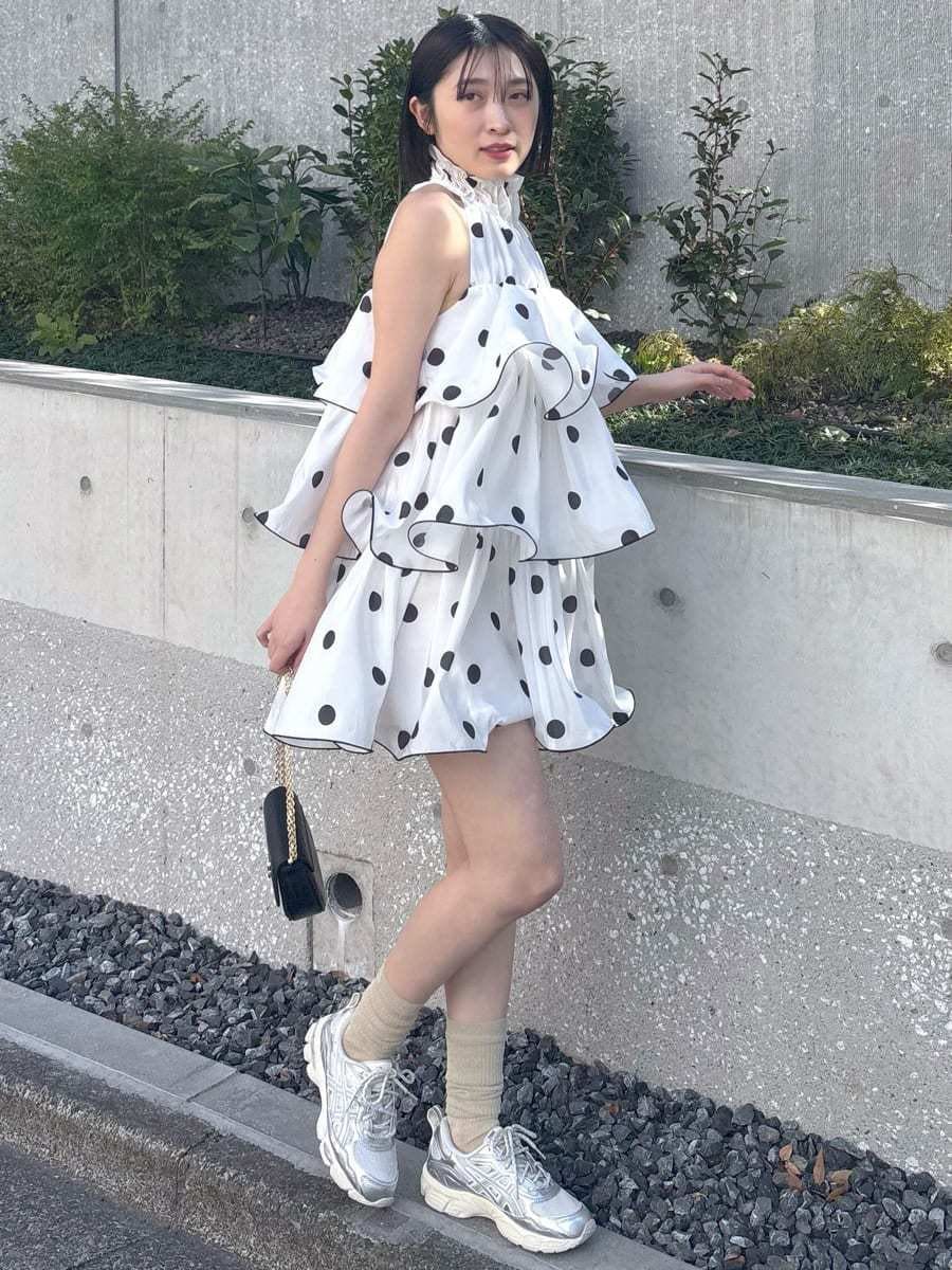 ホワイト系のワンピース、ブラック系のショルダーバッグ、シルバー系のスニーカーを着用したレディースの冬コーディネートの2枚目の写真