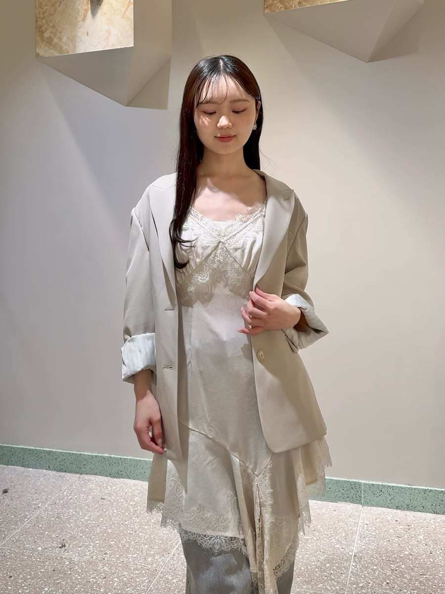 ベージュ系のテーラードジャケット、グレー系のデニムパンツ、ホワイト系のキャミソールを着用したレディースの春コーディネートの7枚目の写真