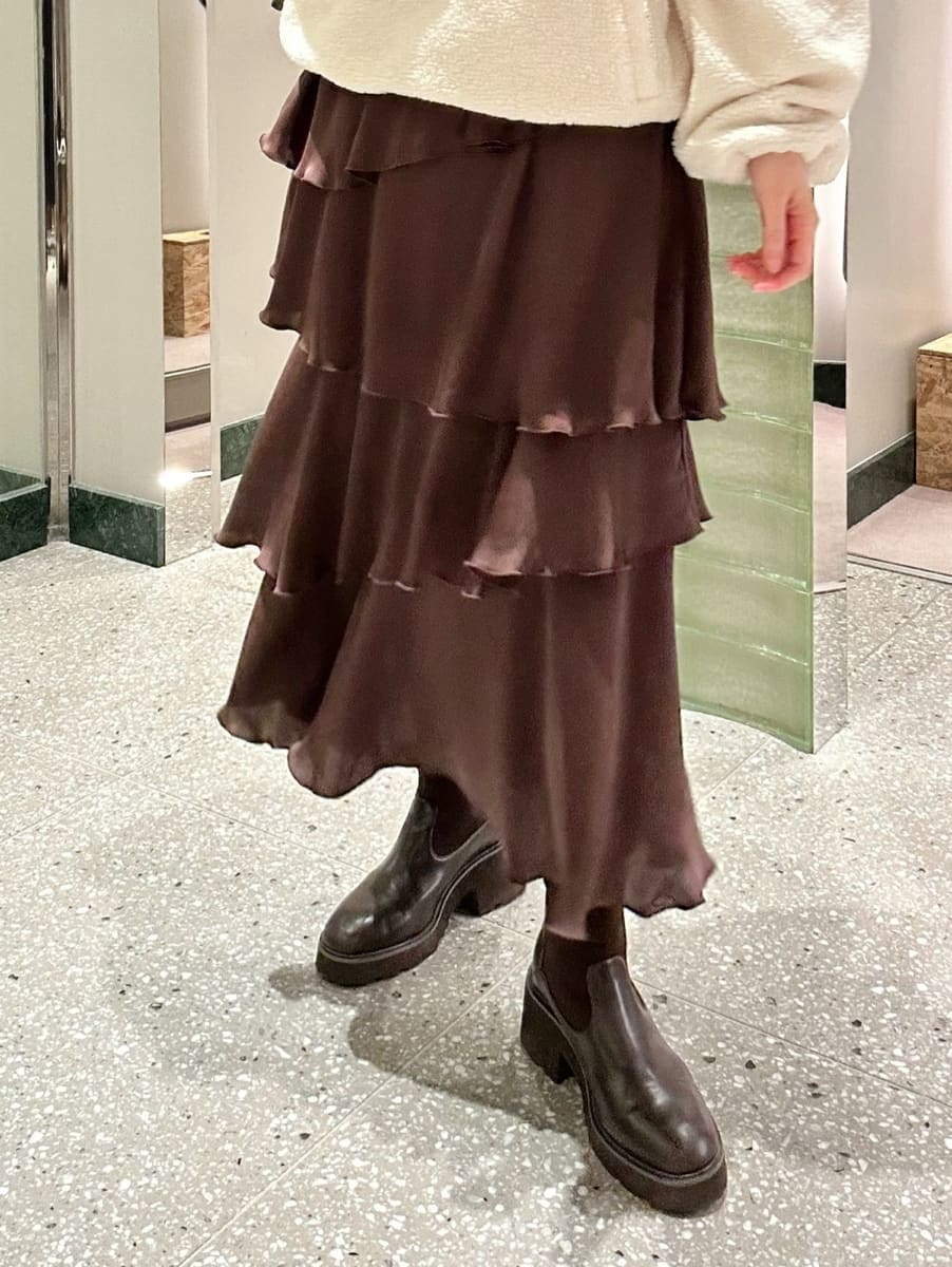 ホワイト系のTシャツ/カットソー、ブラウン系のスカート、イエロー系のボストンバッグを着用したレディースの秋コーディネートの3枚目の写真