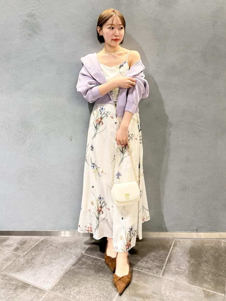 パープル系のパーカー、ホワイト系のワンピース、ブラウン系のパンプスを着用したレディースの冬コーディネートの8枚目の写真