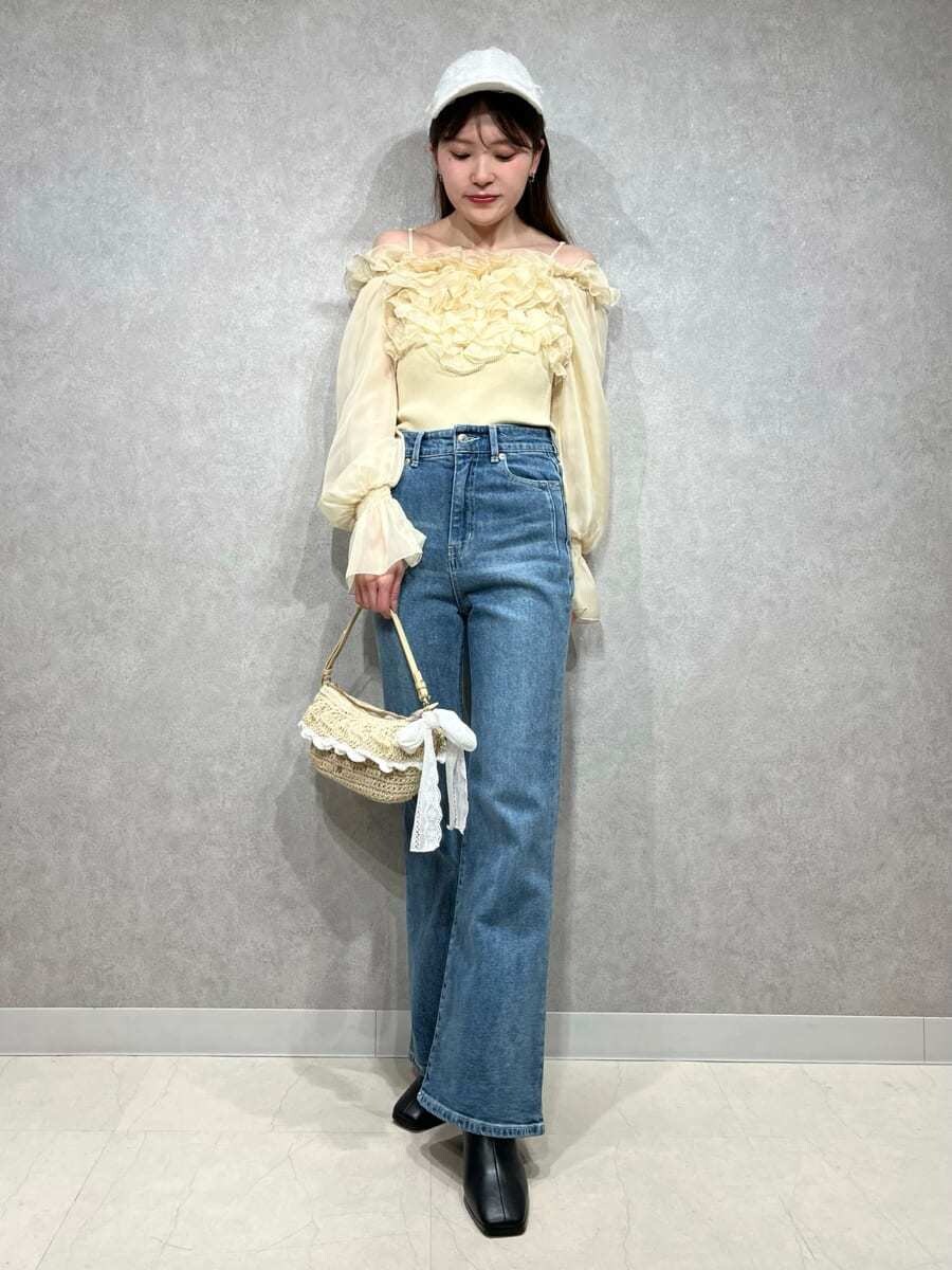 ブルー系のその他パンツ、イエロー系のニット/セーター、ホワイト系のキャップを着用したレディースの冬コーディネートの7枚目の写真