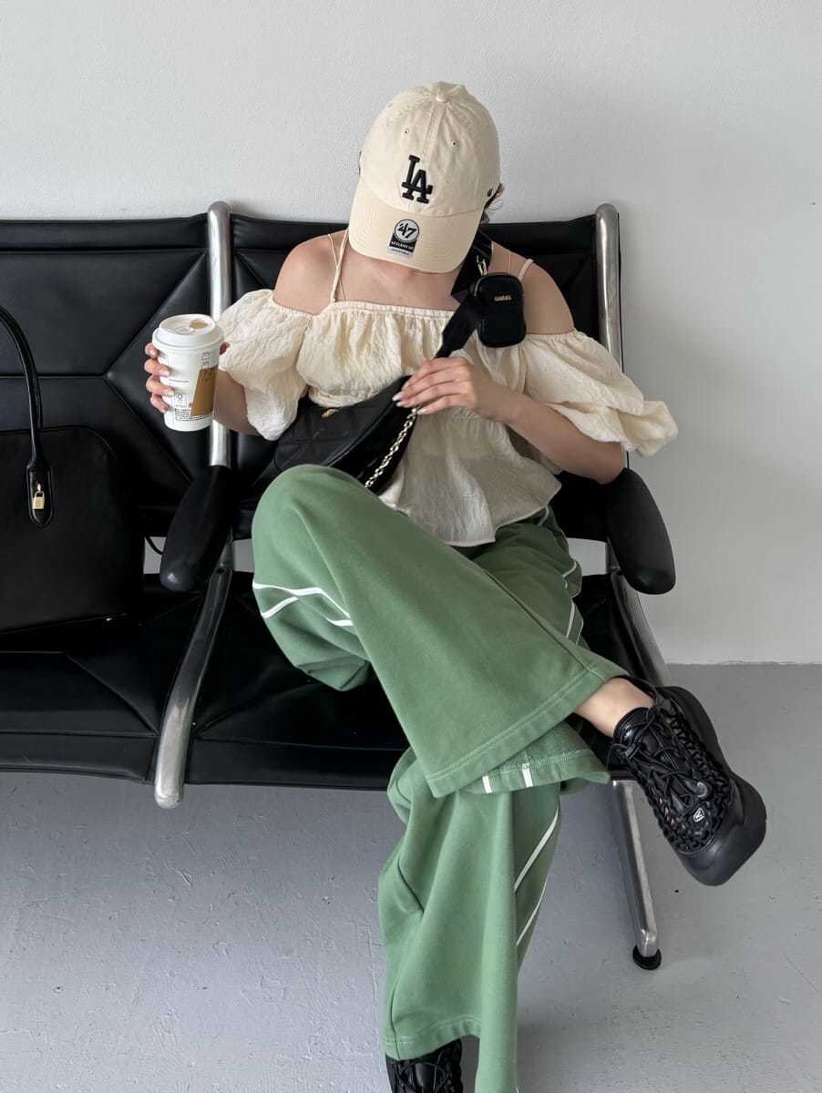 グリーン系のスウェットパンツ、ブラック系のショルダーバッグ、ブラック系のサンダルを着用したレディースの夏コーディネートの3枚目の写真