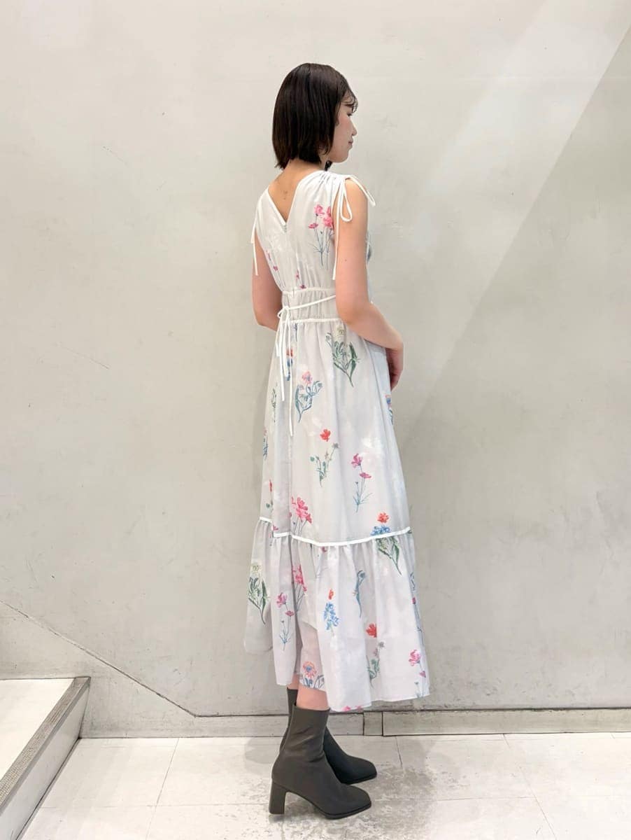 グレー系のワンピース、グレー系のチェスターコート、ゴールド系のイヤリングを着用したレディースの冬コーディネートの5枚目の写真