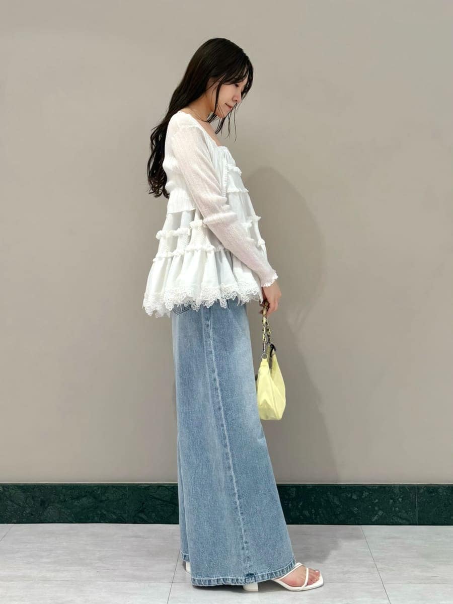 ブルー系のデニムパンツ、ホワイト系のニット/セーター、ホワイト系のカーディガン/ボレロを着用したレディースの夏コーディネートの2枚目の写真