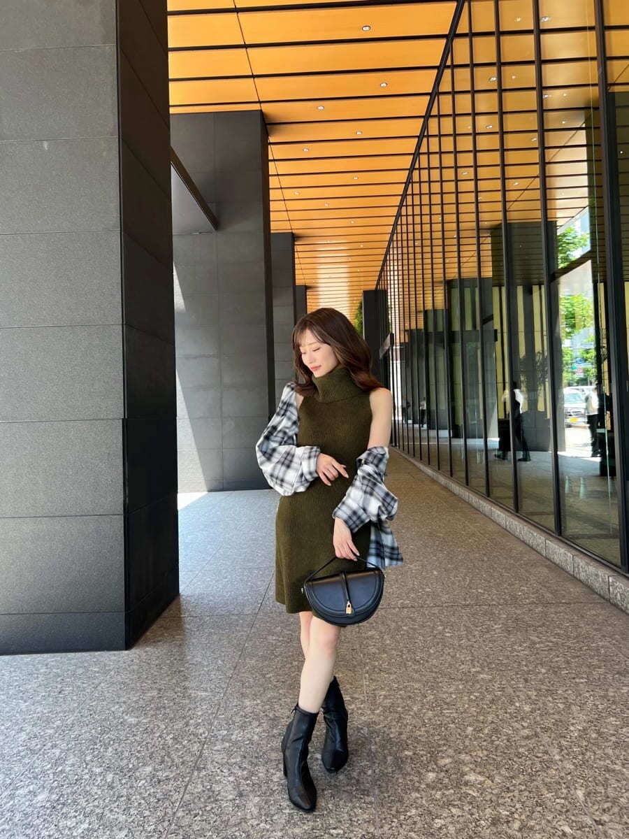 グリーン系のワンピース、ブラック系のシャツ/ブラウス、ブラック系のハンドバッグを着用したレディースの秋コーディネートの2枚目の写真