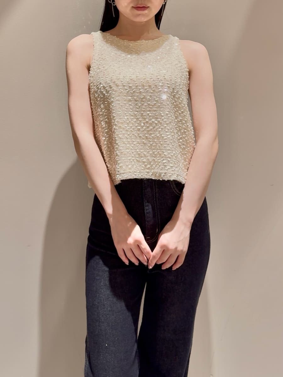 ホワイト系のタンクトップ、ブルー系のデニムパンツ、ベージュ系のハンドバッグを着用したレディースの夏コーディネートの5枚目の写真