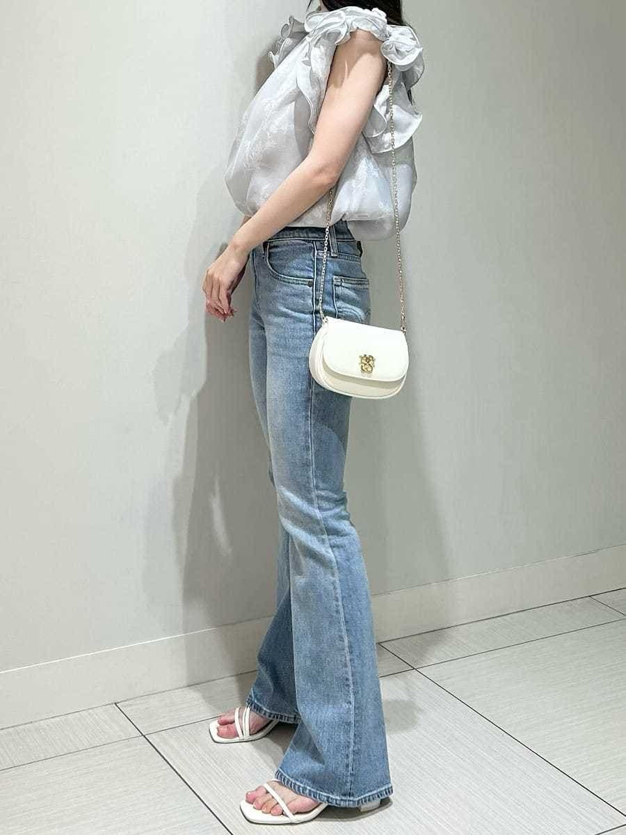 ブルー系のデニムパンツ、ホワイト系のショルダーバッグ、グレー系のシャツ/ブラウスを着用したレディースの春コーディネートの5枚目の写真