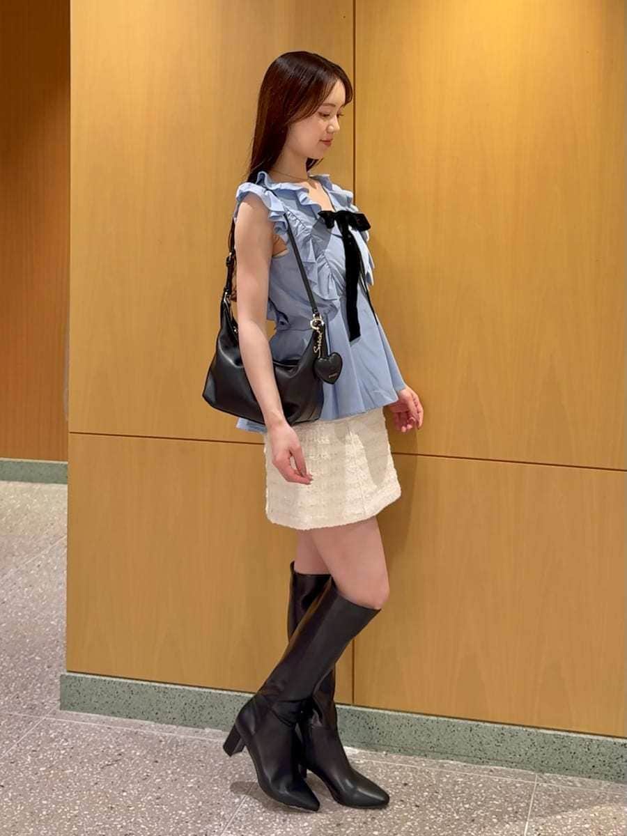 ホワイト系のスカート、ブルー系のシャツ/ブラウス、ブラック系のブーツを着用したレディースの夏コーディネートの3枚目の写真