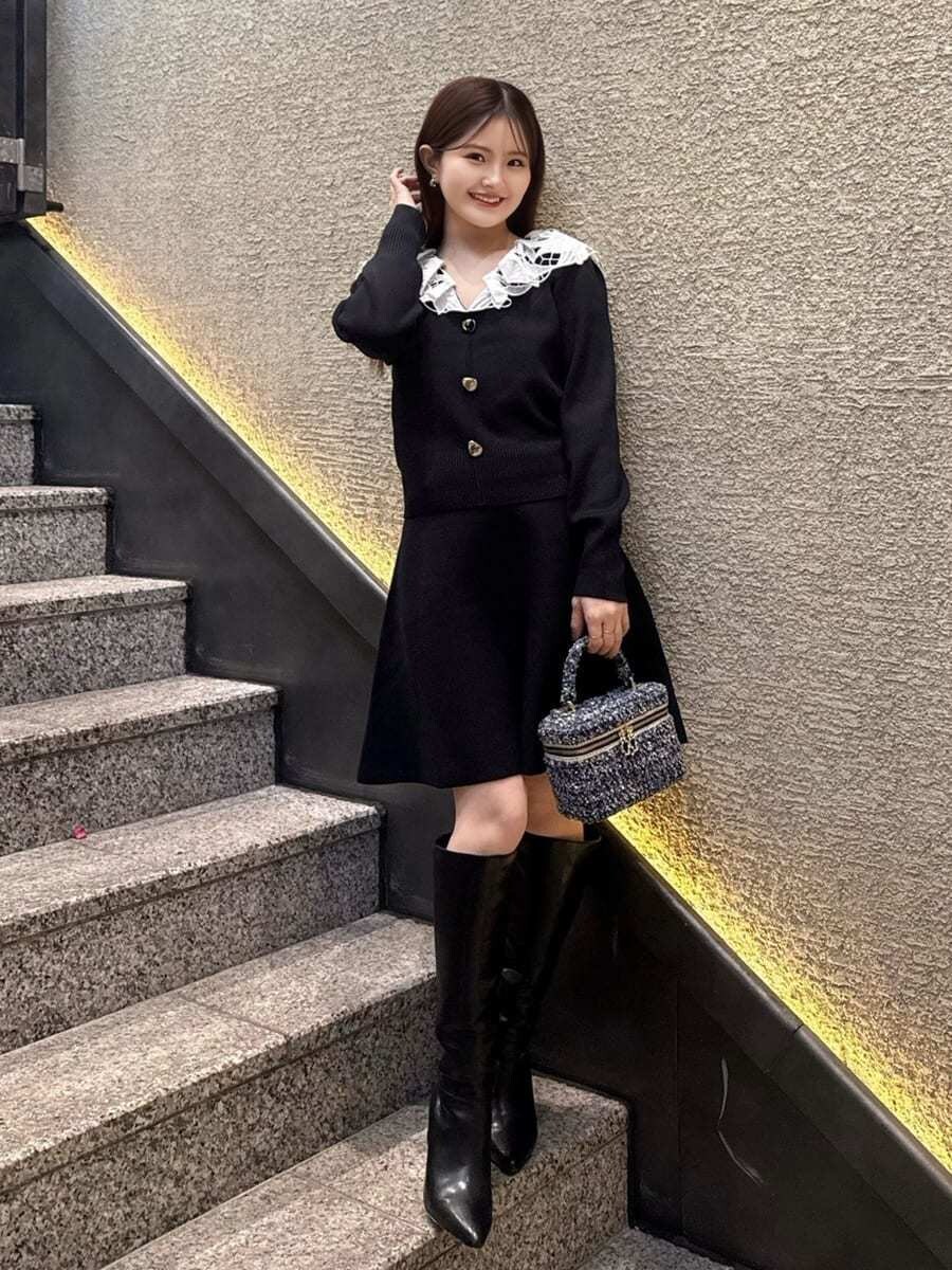 ブラック系のブーツ、ブルー系のハンドバッグ、ブラック系のワンピースを着用したレディースの冬コーディネートの4枚目の写真