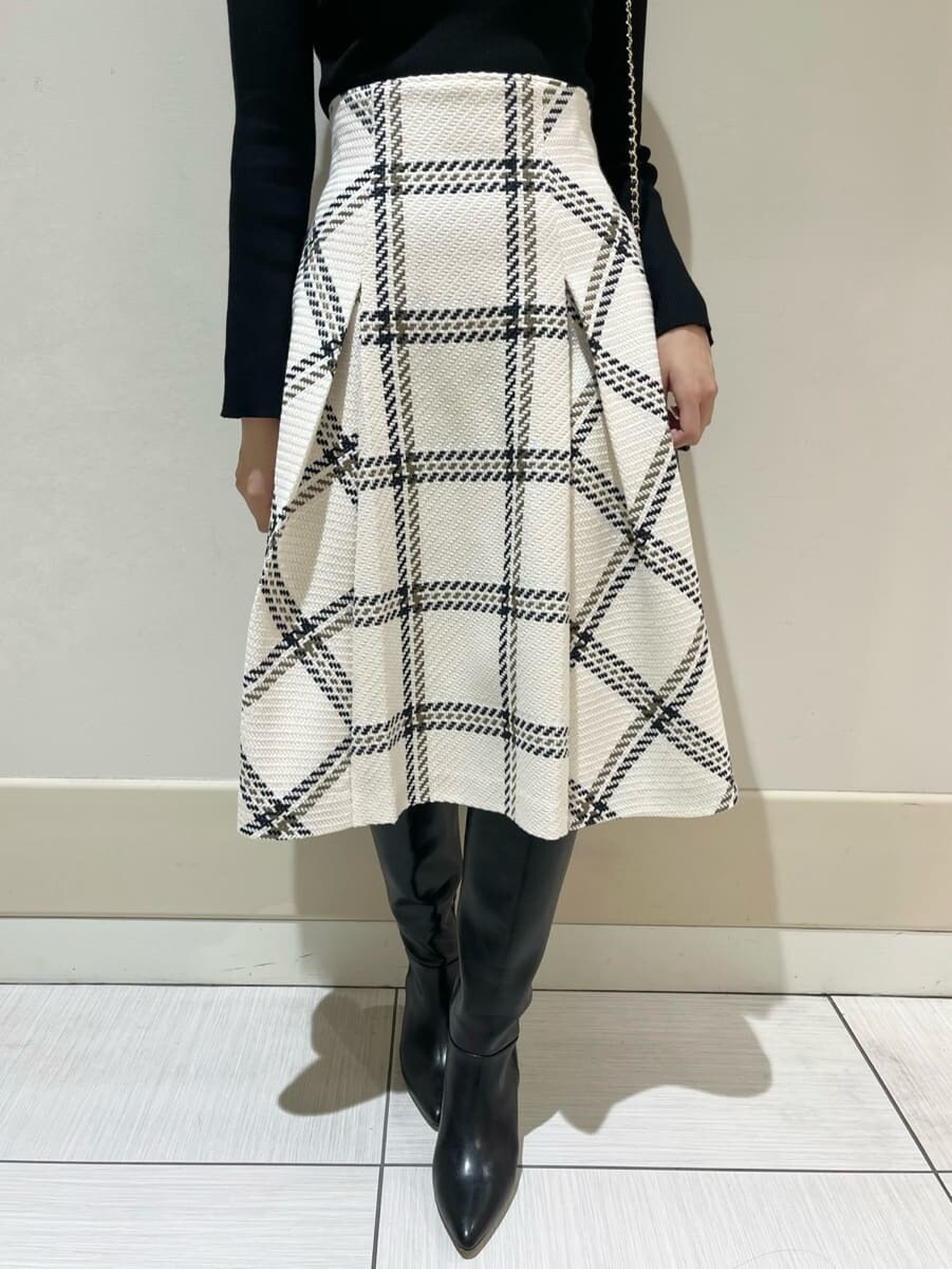 ブラック系のニット/セーター、ホワイト系のスカート、ブラック系のショルダーバッグを着用したレディースの秋コーディネートの5枚目の写真