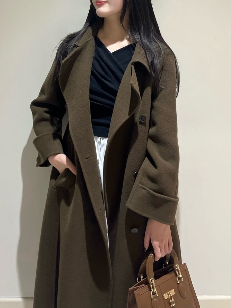 ブラック系のブーツ、ブラウン系のハンドバッグ、ブラウン系のチェスターコートを着用したレディースの冬コーディネートの3枚目の写真