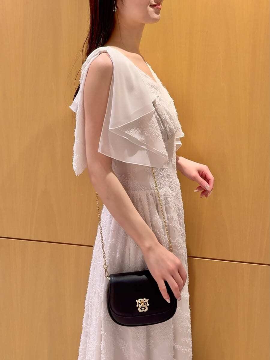 ホワイト系のワンピース、その他のパンプス、ブラック系のショルダーバッグを着用したレディースの春コーディネートの7枚目の写真